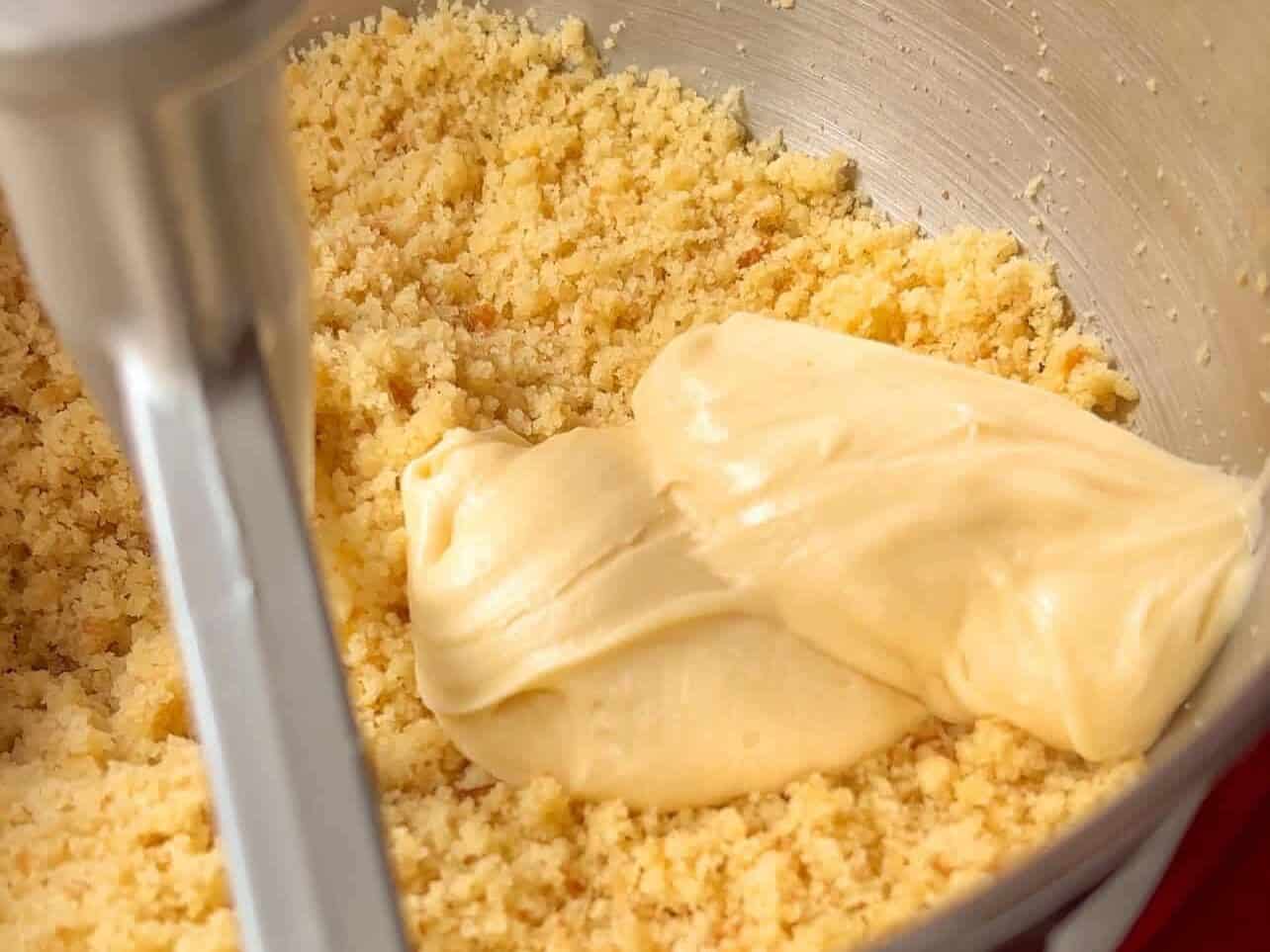 Adding homemade buttercream to crumbled cake to make cake pops