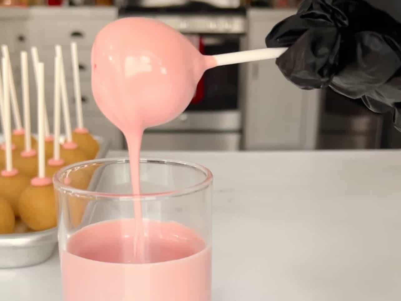 Tap Starbucks copycat birthday cake pop stick to allow excess candy melt to drip off