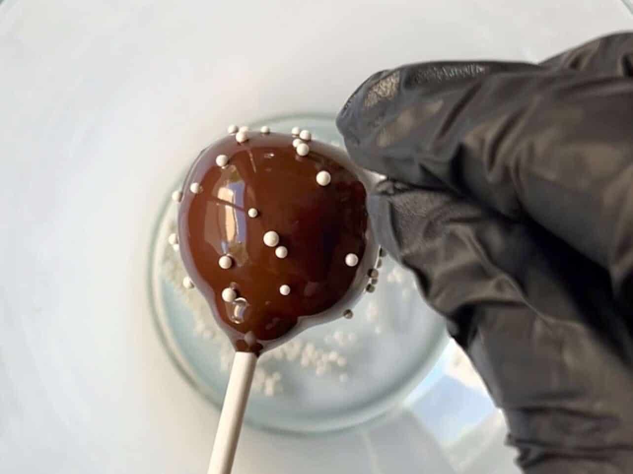 sprinkle nonpareils on starbucks copycat chocolate cake pop before candy melt dries