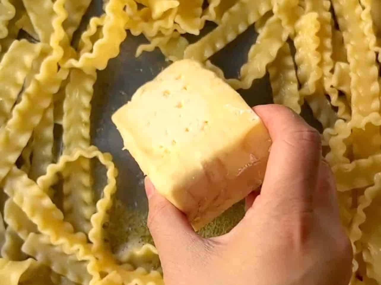add pasta and brie without the rind to pan