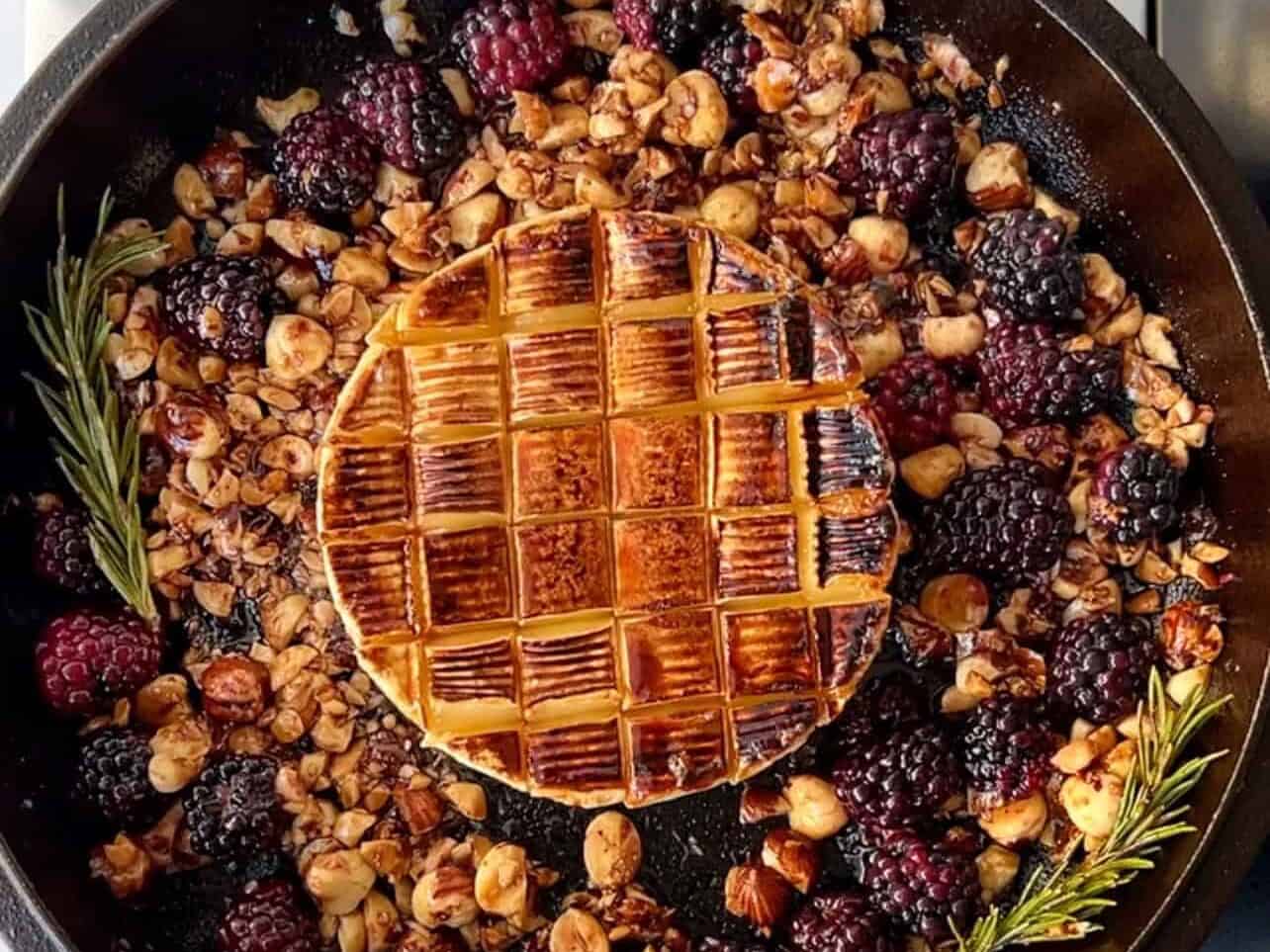 add brie in skillet and bake with blackberries, rosemary, and chopped hazelnuts