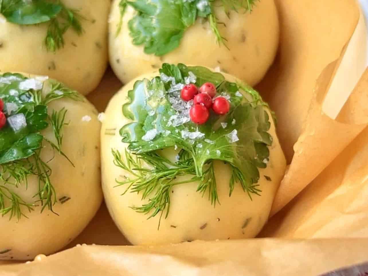decorate dough with dill, parsley, pink peppercorns, and salt to make festive holiday dinner rolls