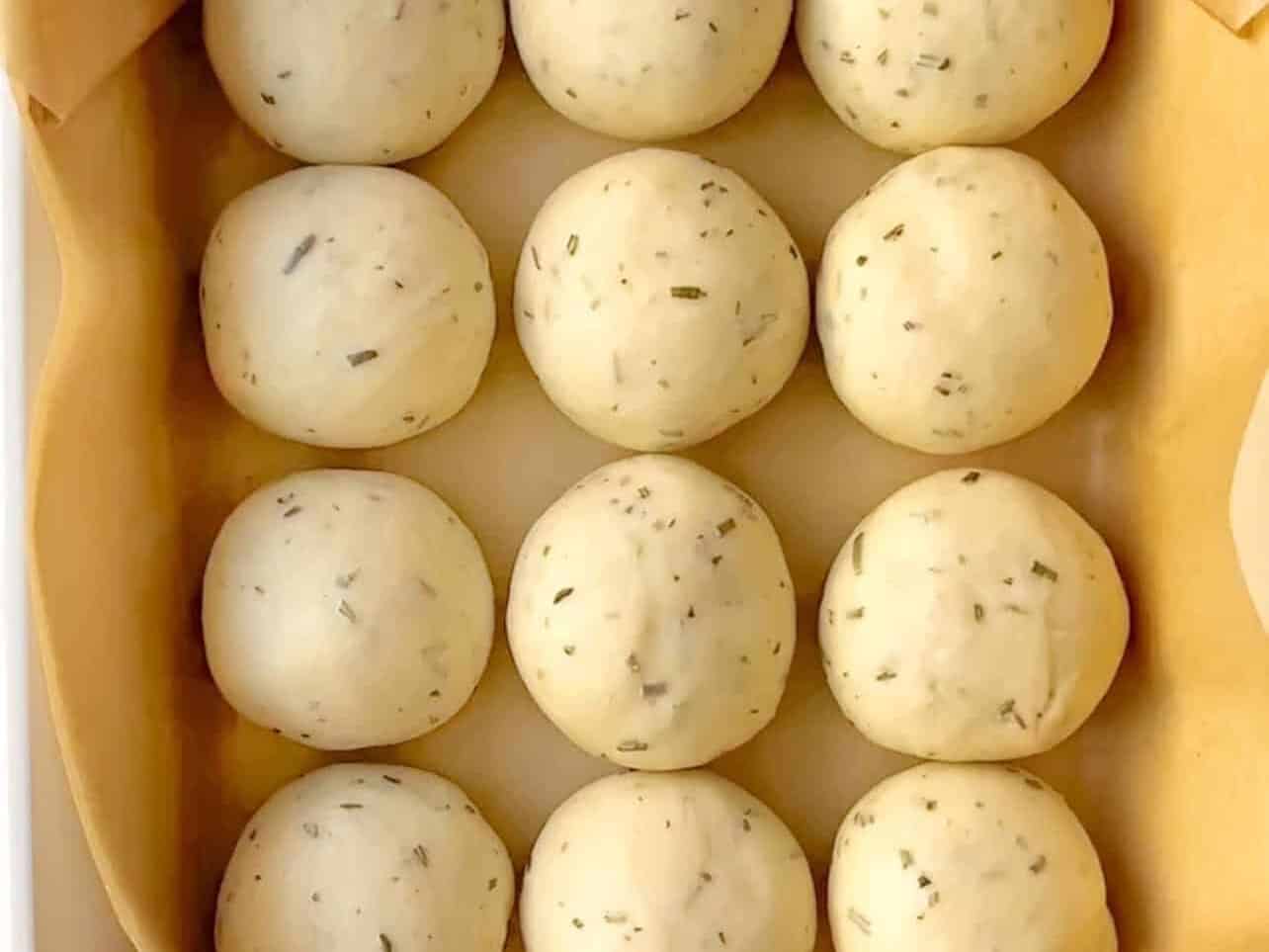 dough balls in lined pan to make dinner rolls