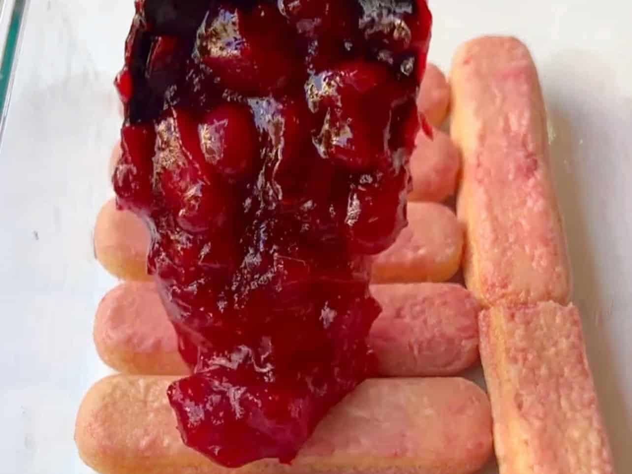 layering dunked ladyfingers and cranberry sauce