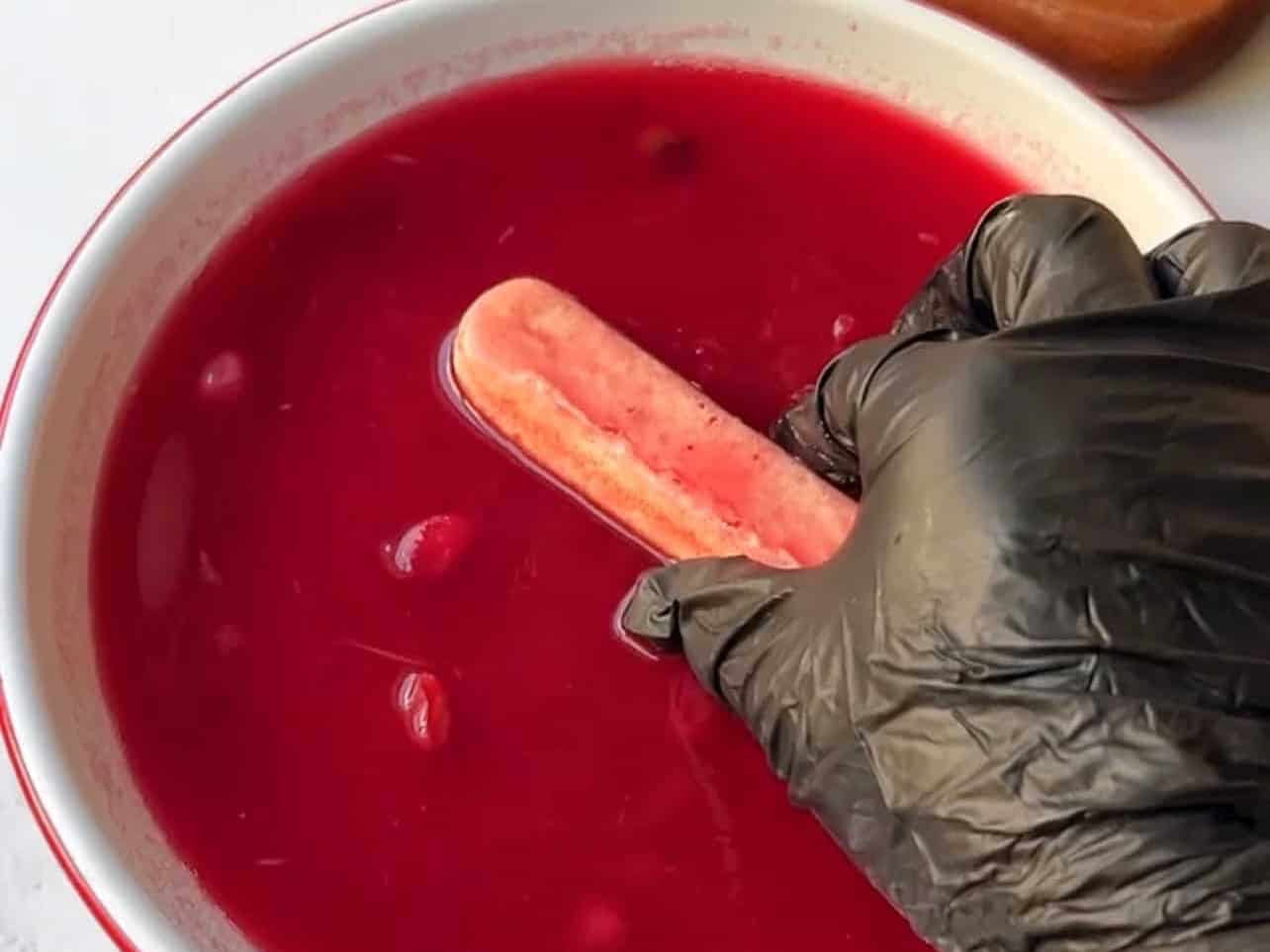 dip ladyfingers into cranberry syrup