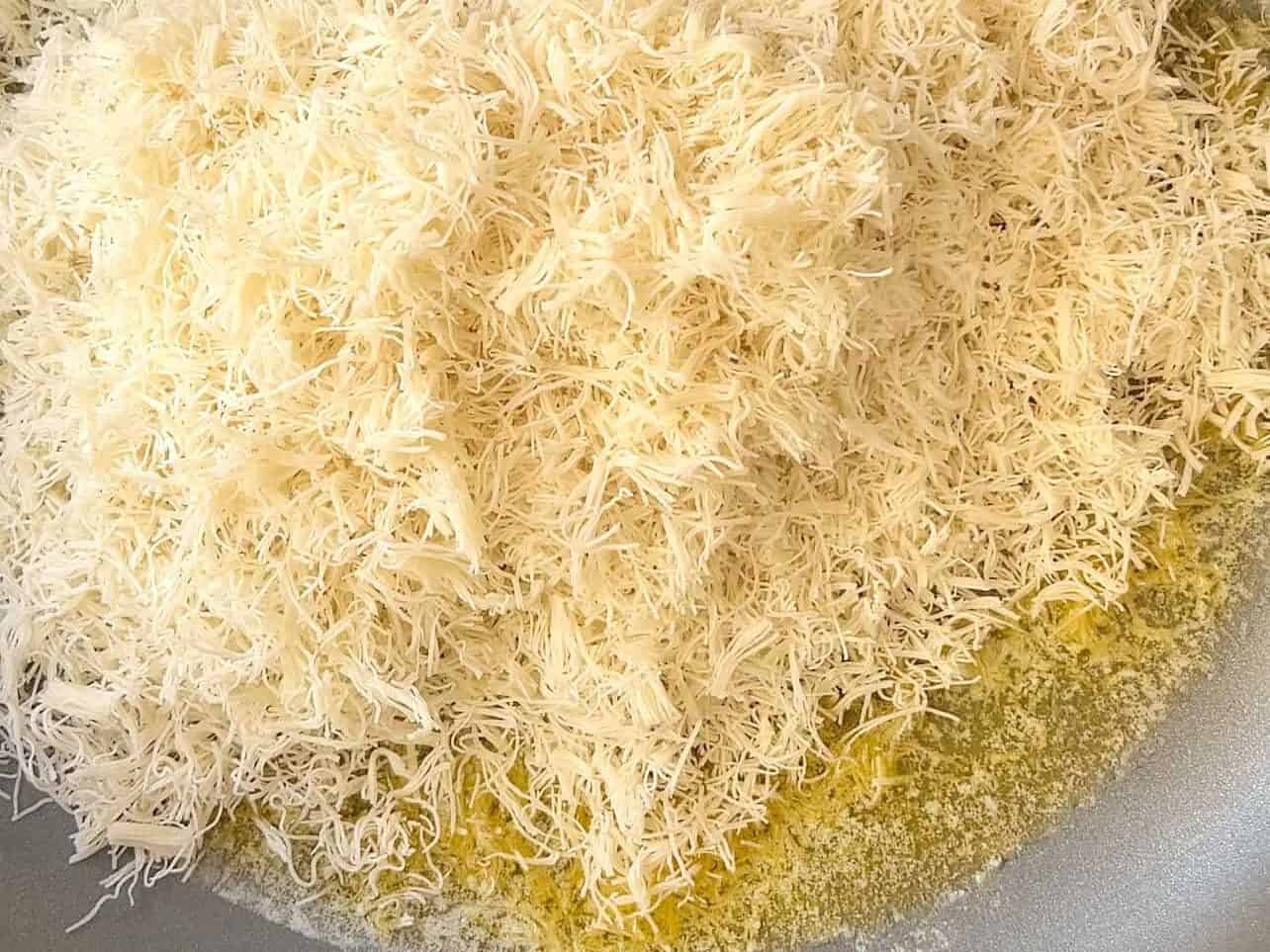 toasting kataifi with melted butter on stovetop