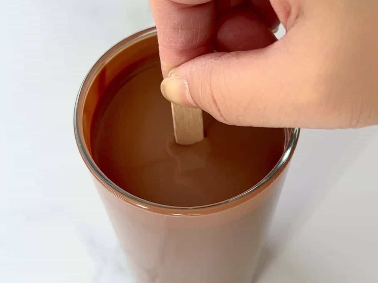 submerge ice cream bar until wooden stick