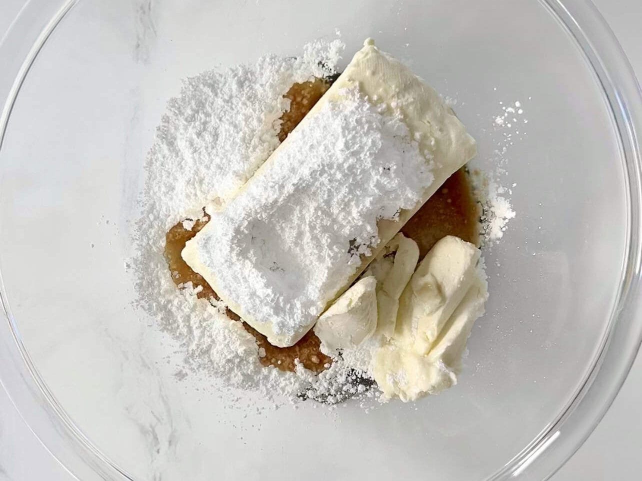 combining ingredients in a bowl for cream cheese frosting