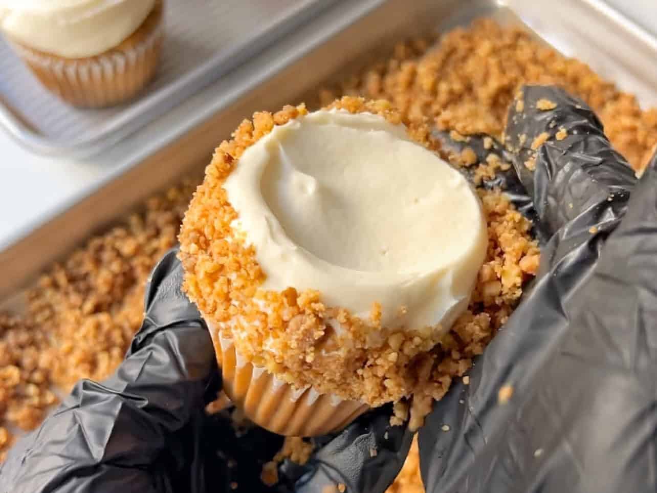 press on walnut crumble along all sides of cupcake frosting