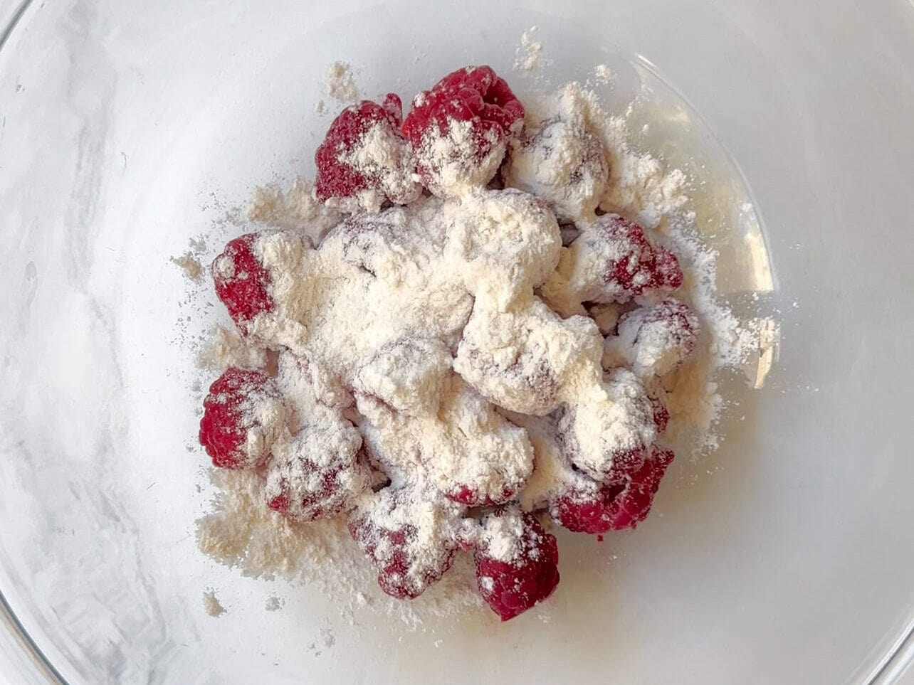 Dust raspberries with flour in a bowl