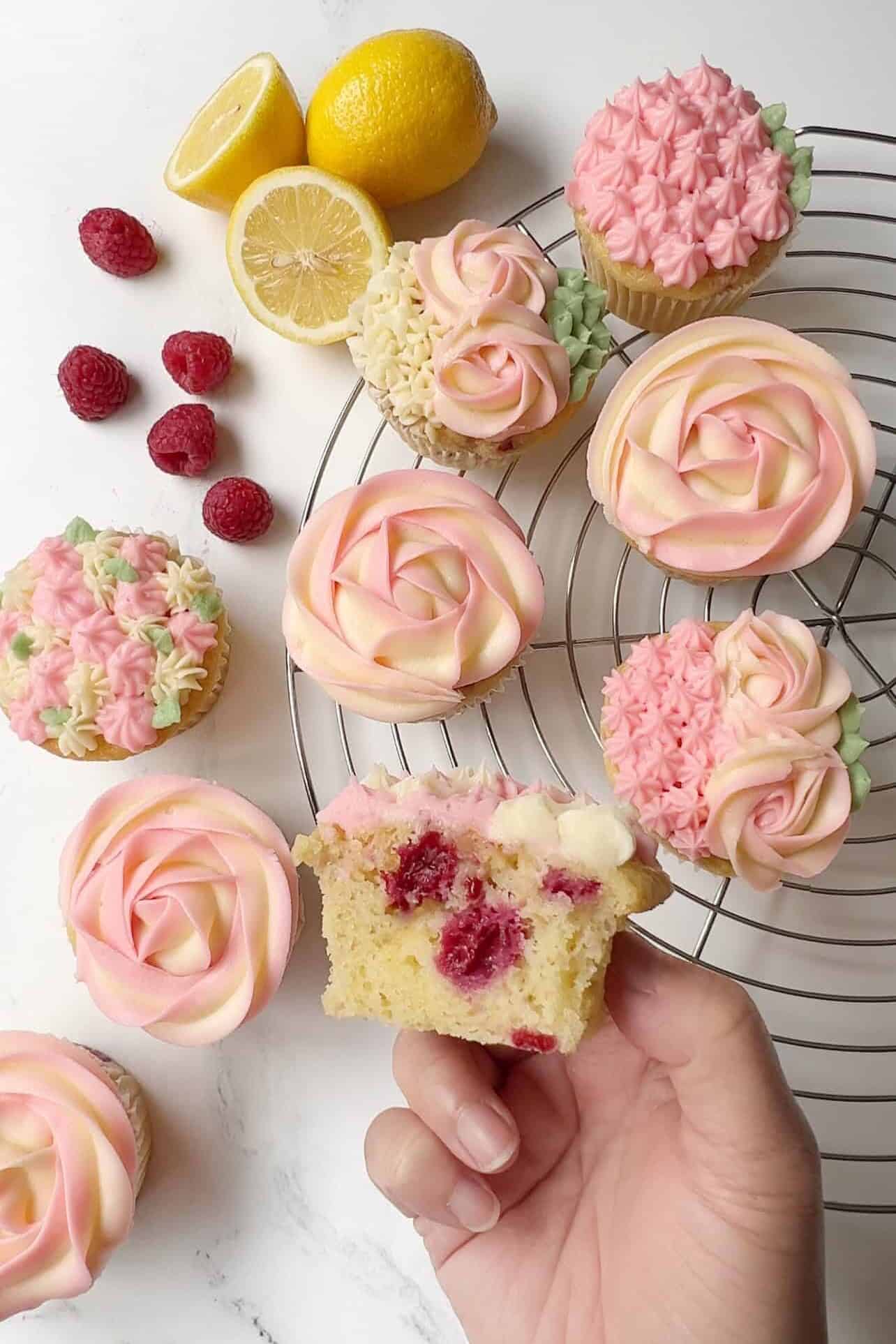 bird's eye view of pink and white lemon raspberry cupcakes with lemon cream cheese frosting on a table