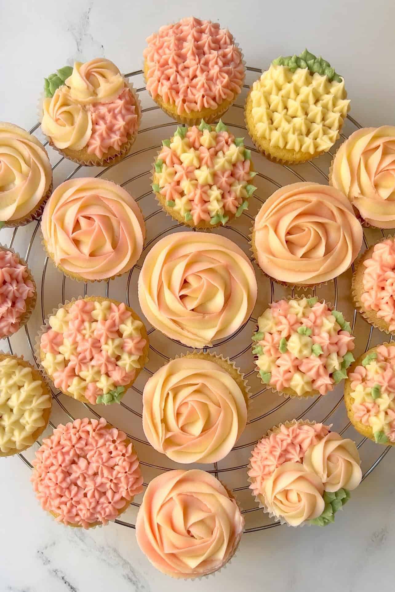 bird's eye view of pink and white lemon raspberry cupcakes with lemon cream cheese frosting on a table