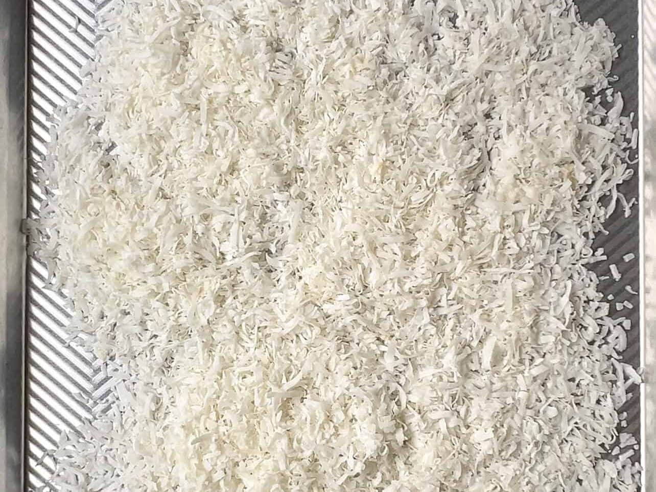 coconut flakes spread on baking sheet