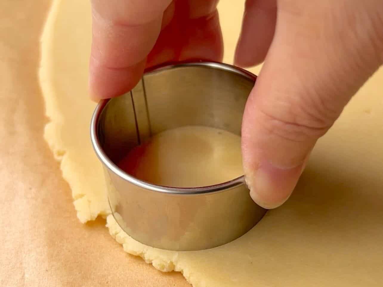 using round cookie cutters to cut donut shaped cookies