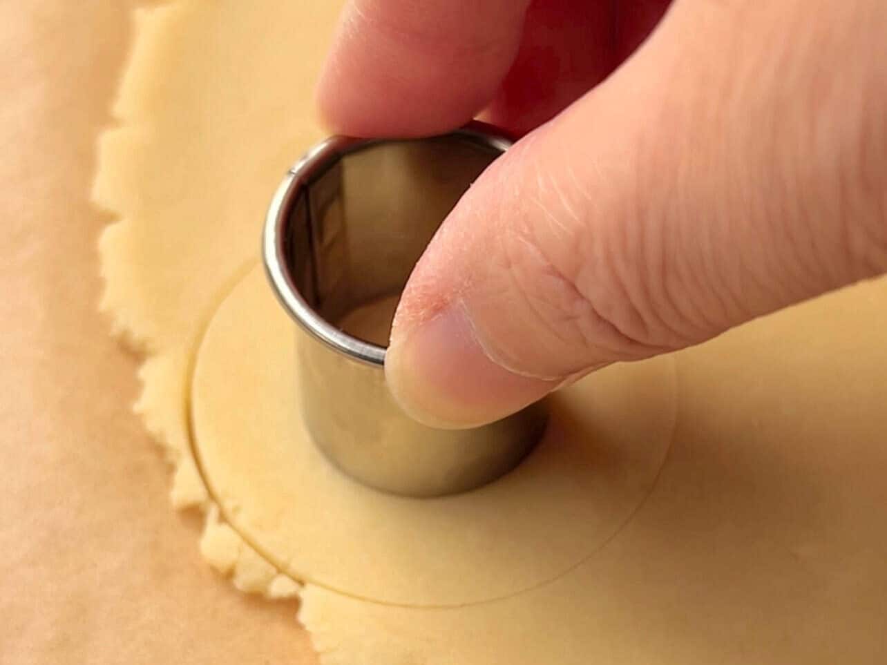 using a small cookie cutter to create donut shaped cookies
