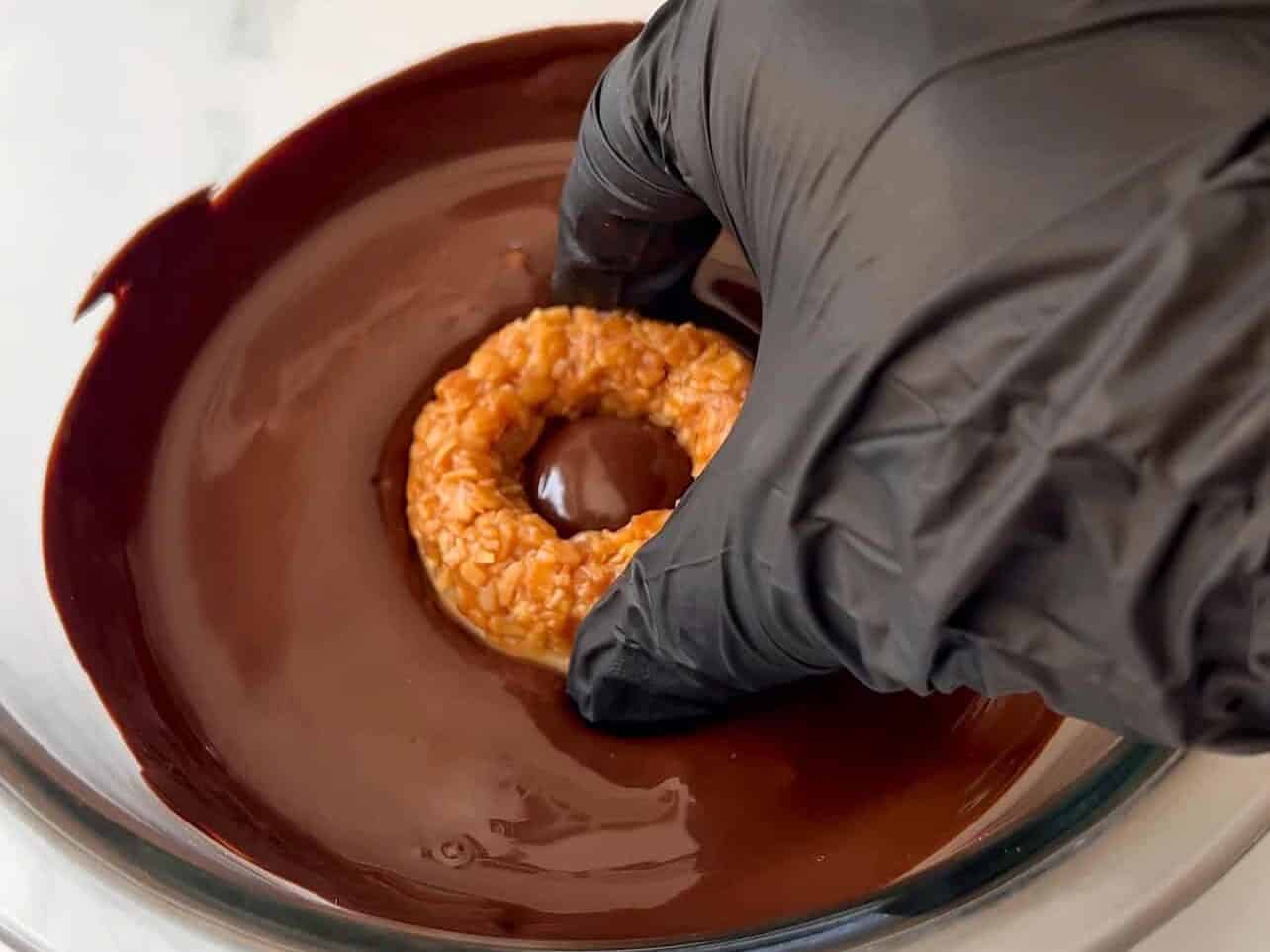 dunking cookie ring bottoms into melted chocolate