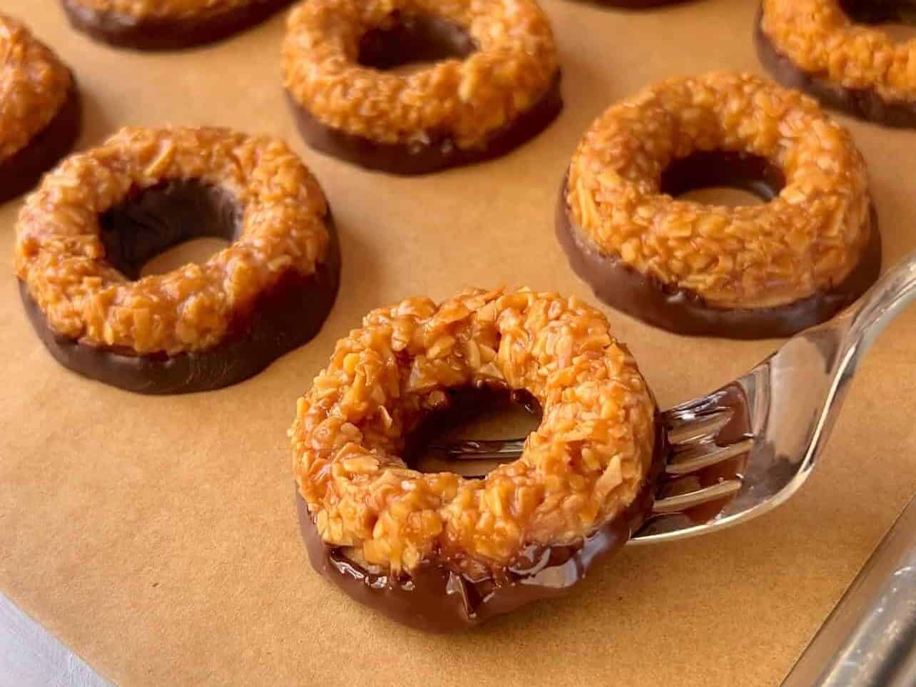 placing Girl Scouts copycat Samoas cookies onto parchment paper