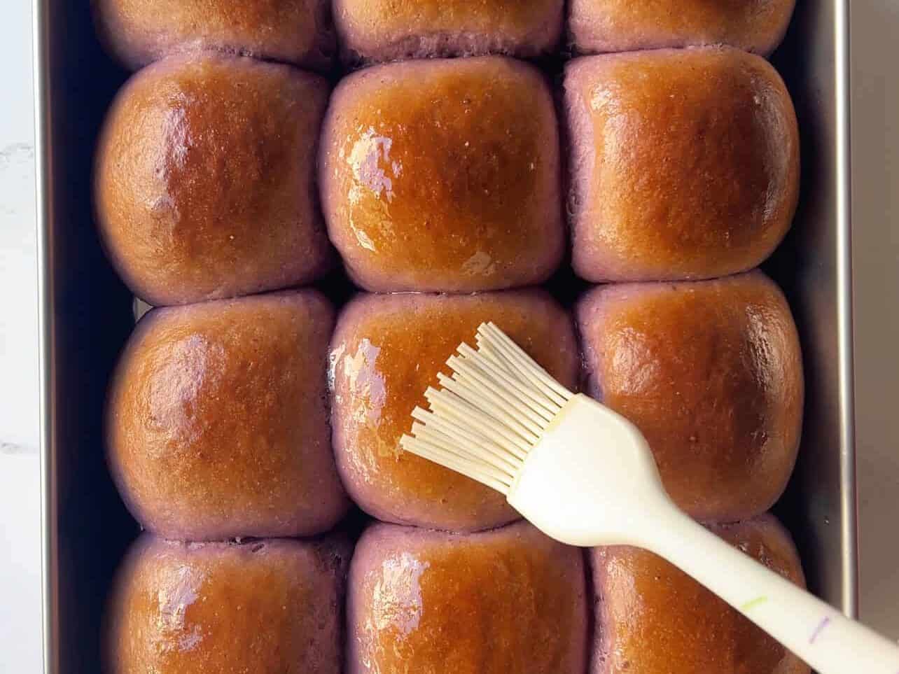 final brush of melted butter on baked ube coconut sweet rolls