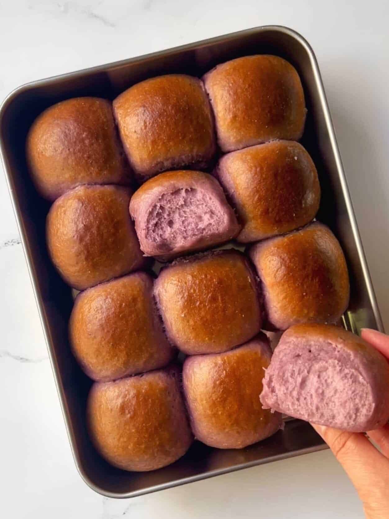 freshly baked ube coconut sweet rolls in baking pan