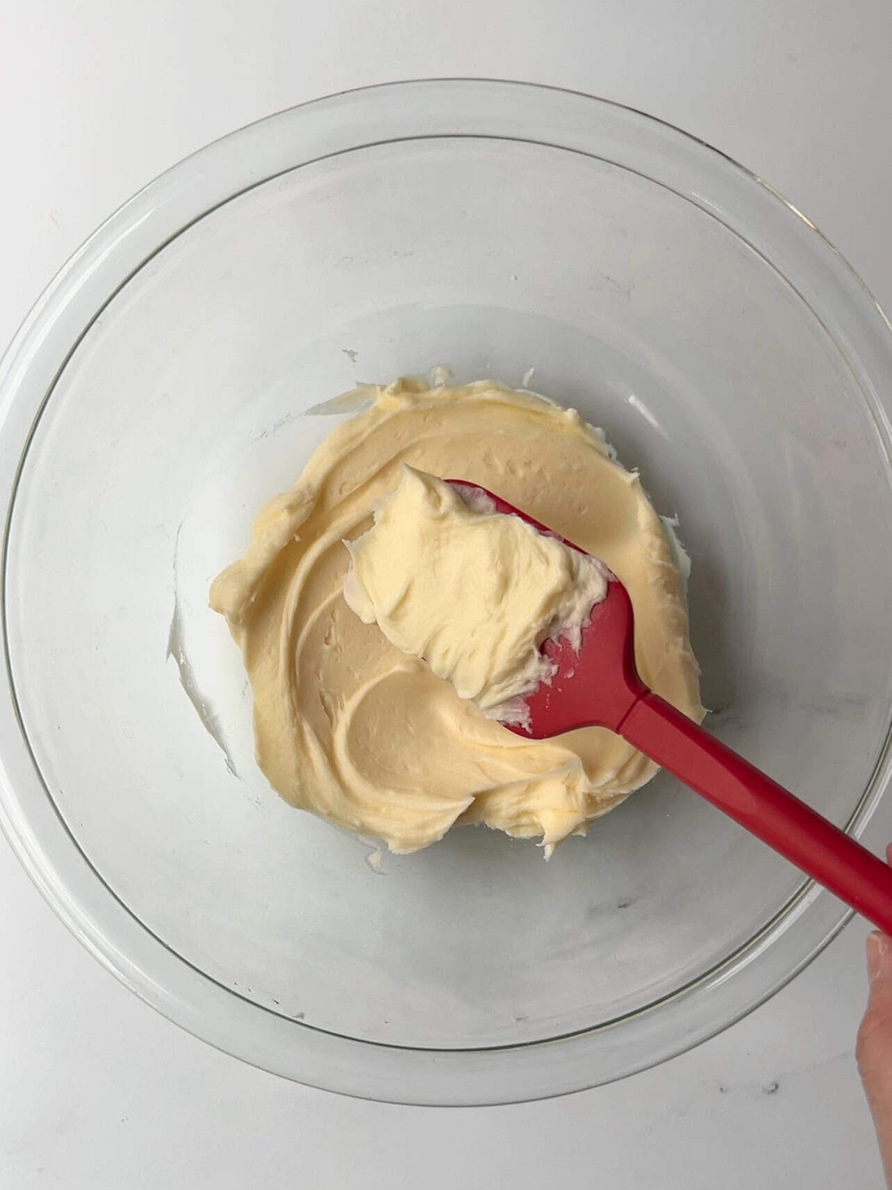 small batch of homemade buttercream in a glass bowl