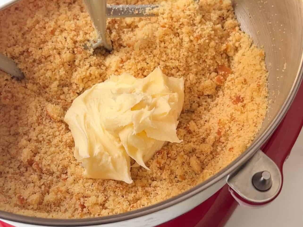 adding homemade buttercream to vanilla cake crumble to creat cake pops