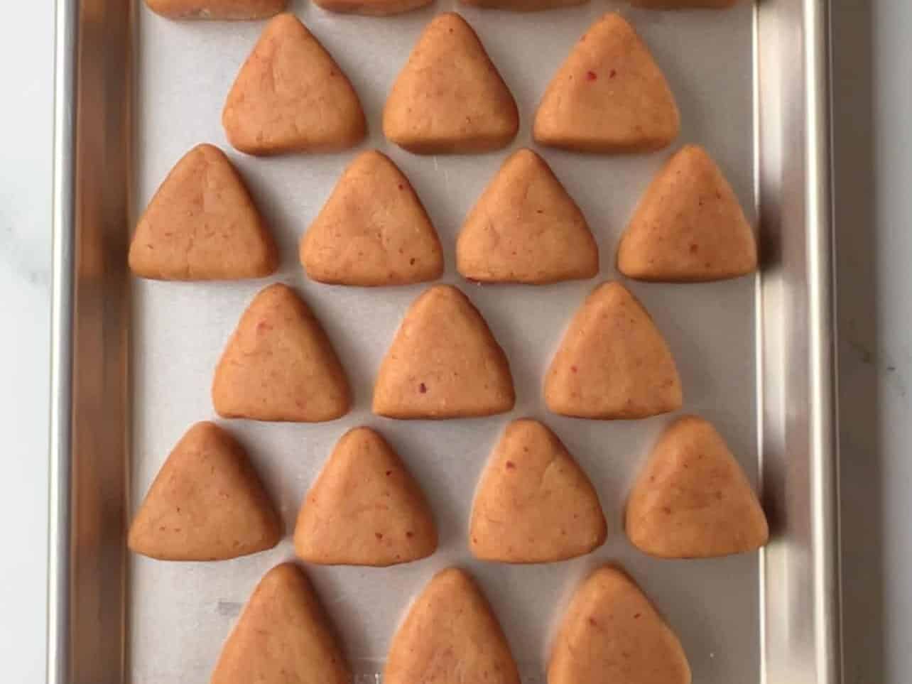 tray of strawberry-shaped cake pops ready for chilling in fridge