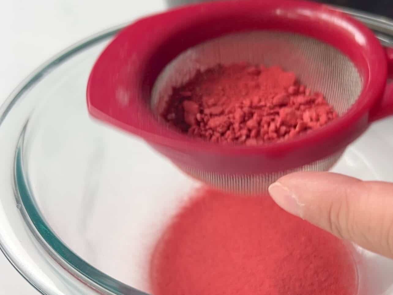 sieve dry milk powder and crushed freeze dried strawberries to remove large flakes and seeds