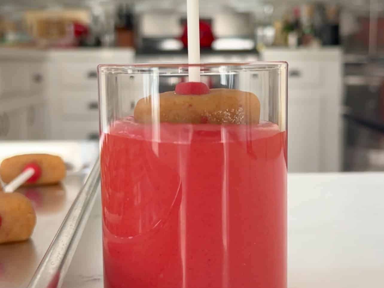 submerge strawberry cake pop into red strawberry crème candy melt