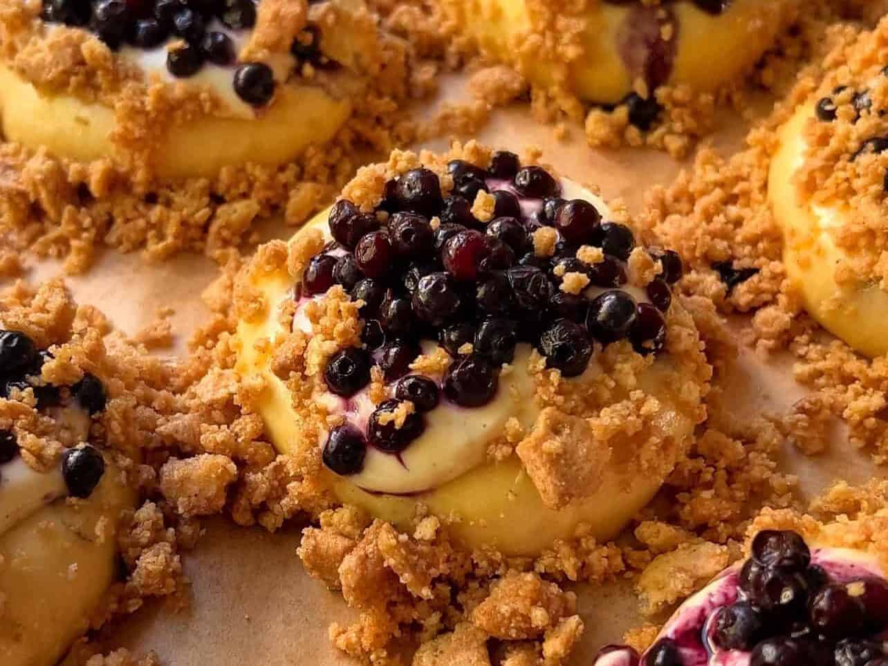 blueberry cheesecake crumble briche rolls made with graham cracker crumble ready to bake