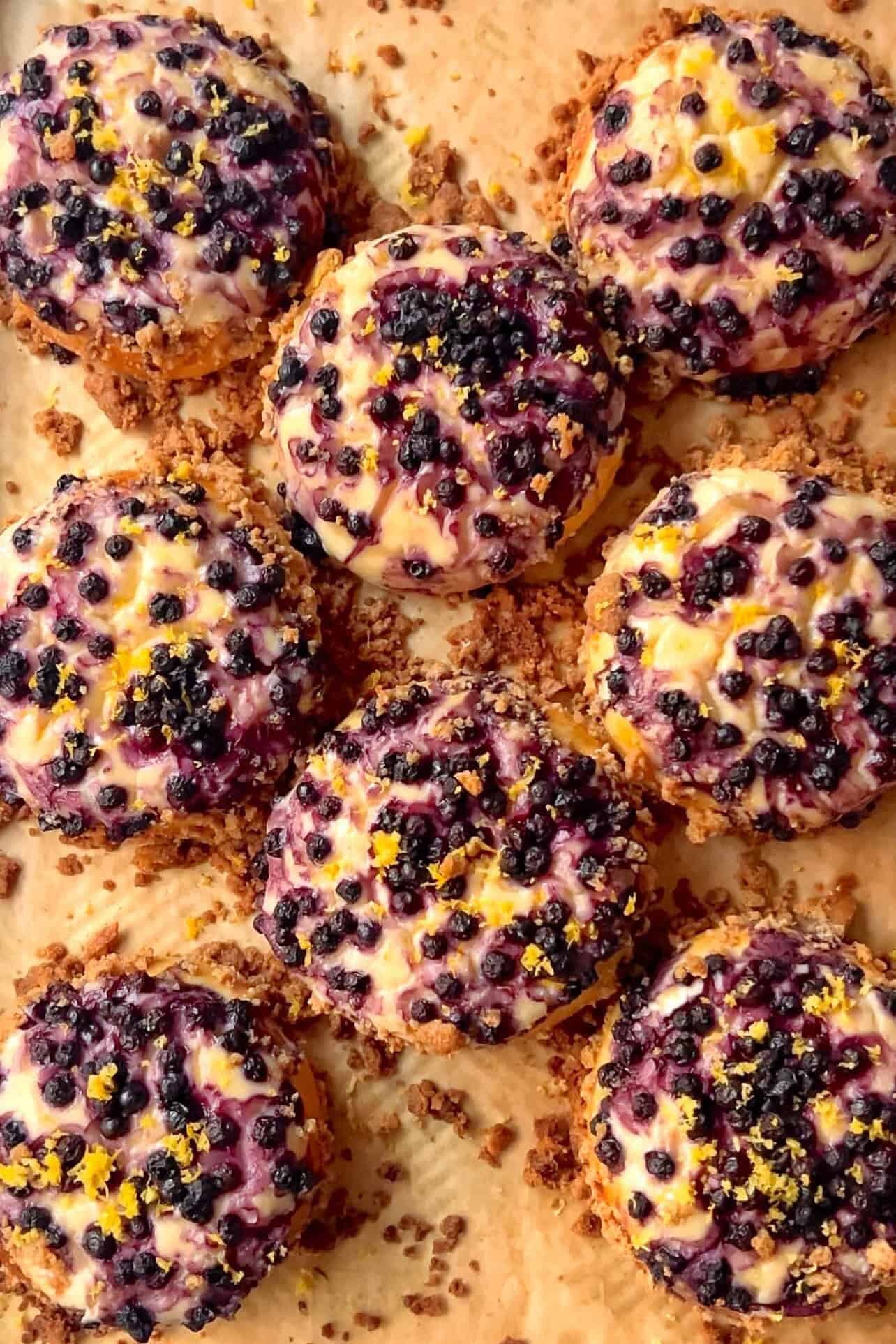 Wild Blueberry Lemon Cheesecake Crumble Brioche Rolls laying on a baking sheet 