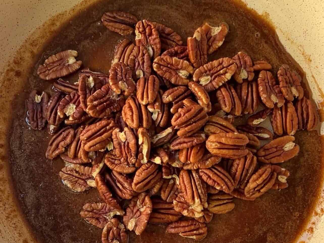 pecan halves in skillet with brown sugar glaze to cook candied pecans.