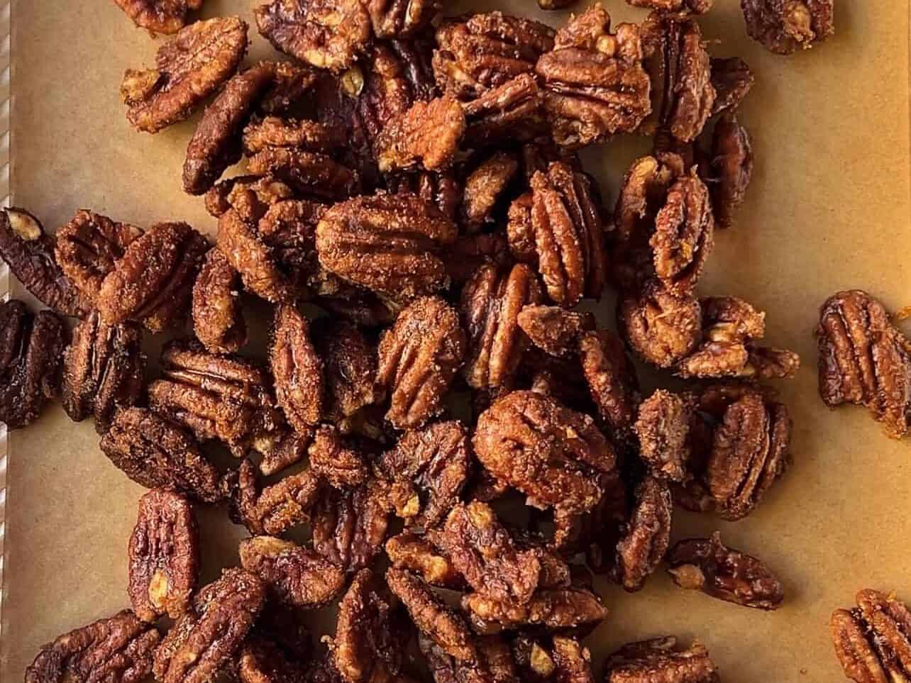 cooling candied pecans on lined baking sheet