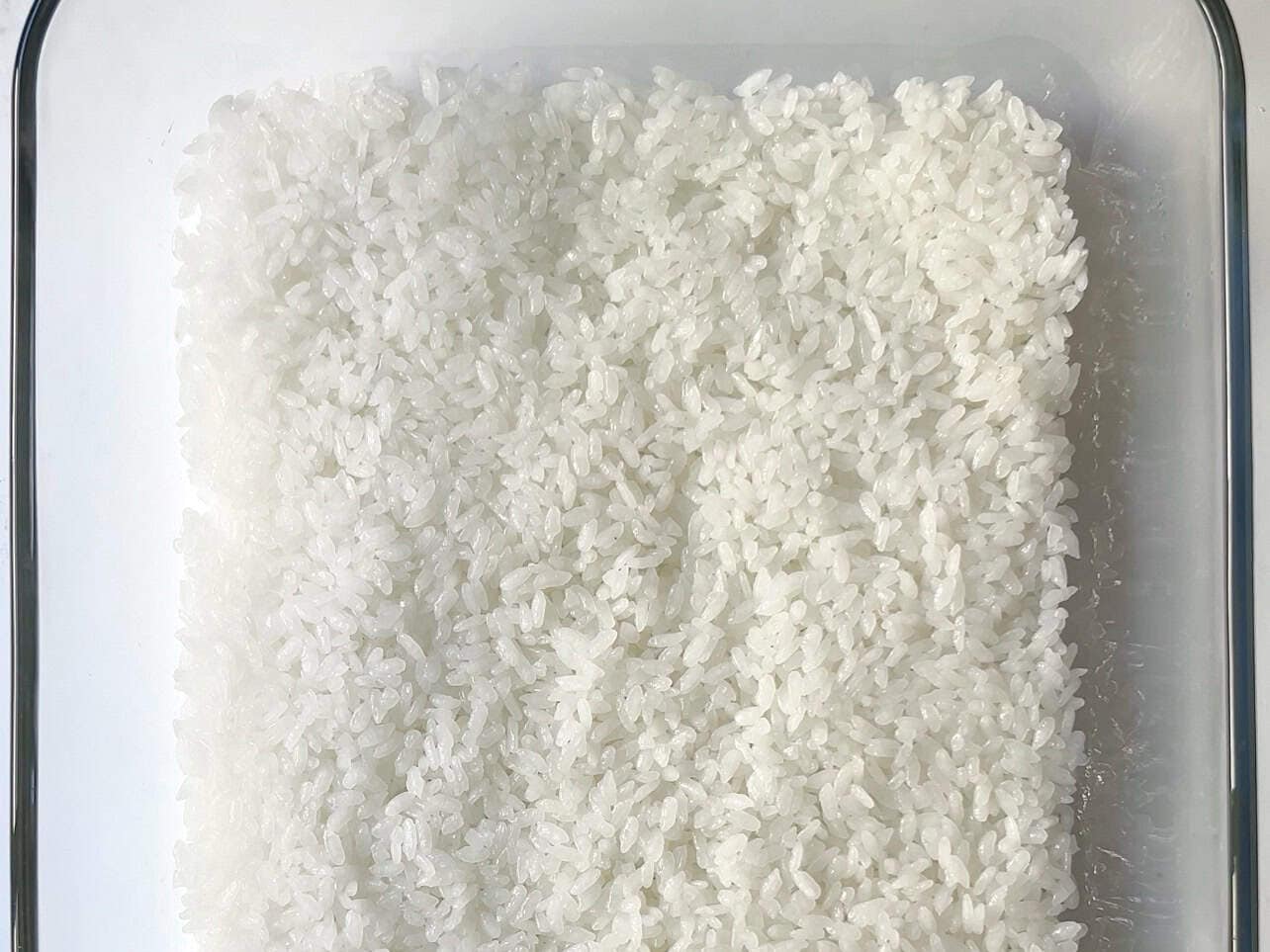 layer sushi rice in casserole dish for sushi bake
