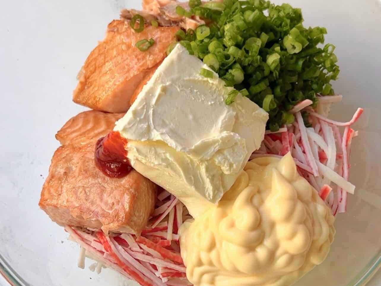 combining seafood with cream cheese, kewpie mayo, green onions, and sriracha for sushi bake