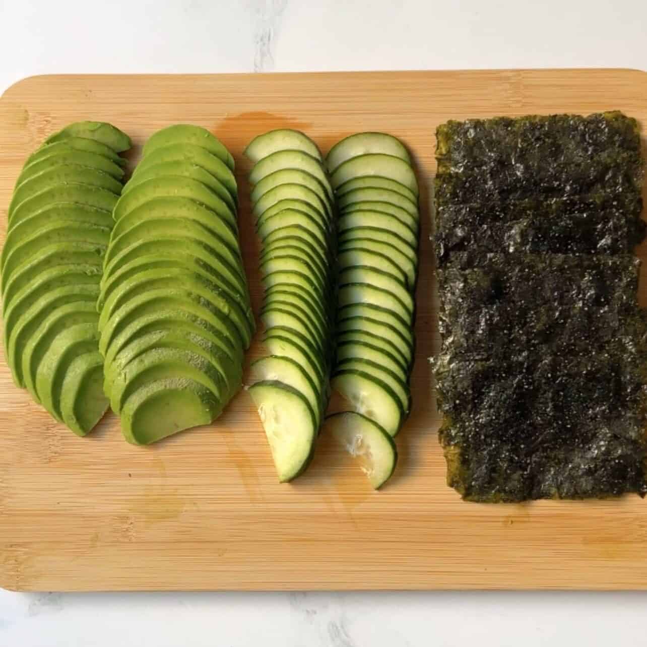 prepared tray of seaweed sheets and sliced cucumber and avocado to enjoy with a sushi bake