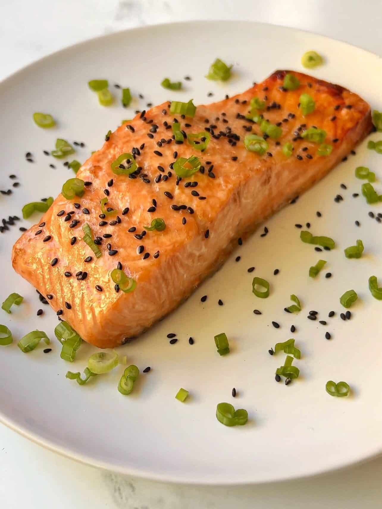 Easy Baked Marinated Salmon plated with black sesame seeds and green onions