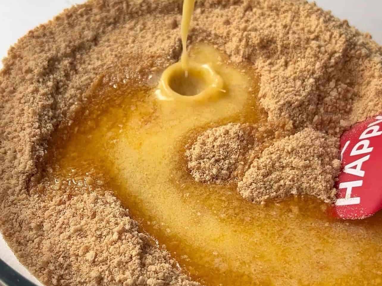 pouring melted butter to graham cracker crumbs in large bowl