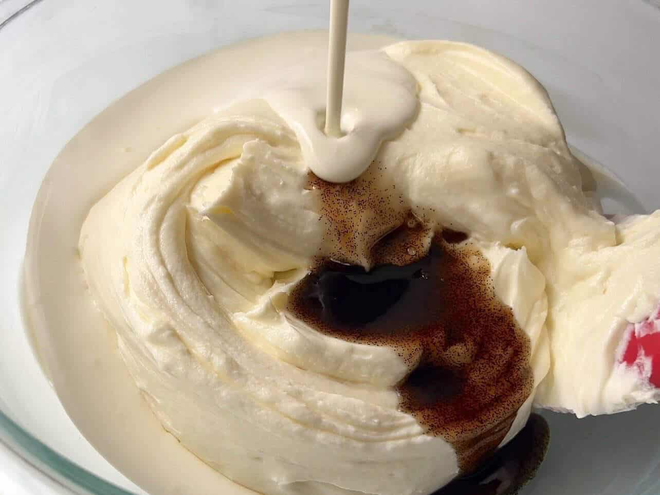 adding vanilla bean paste and heavy cream to cheesecake filling