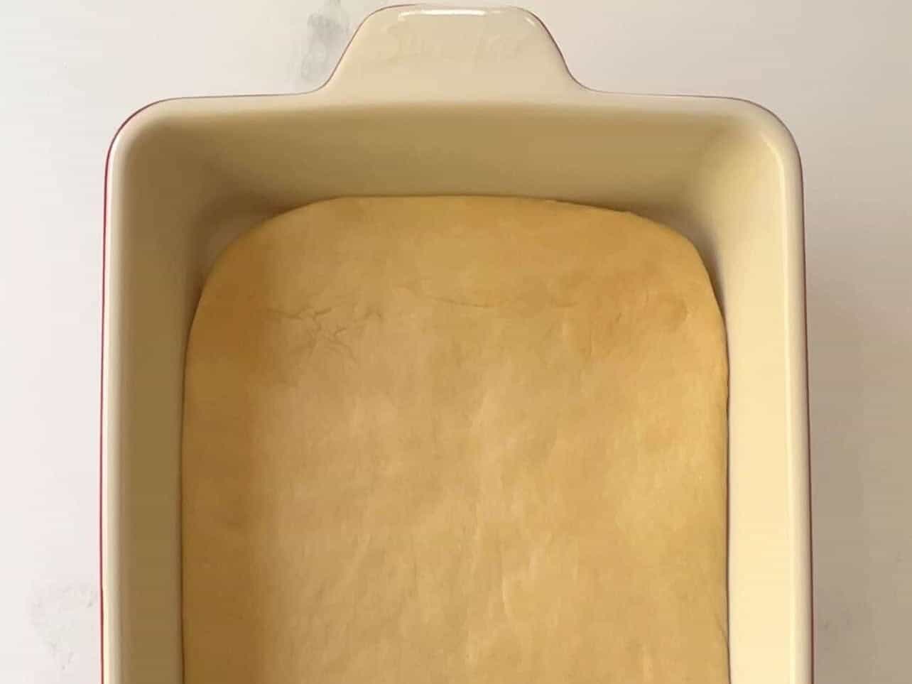 Cinnabon copycat cinnamon roll dough first rise in baking pan to encourage rectangle shape before rolling