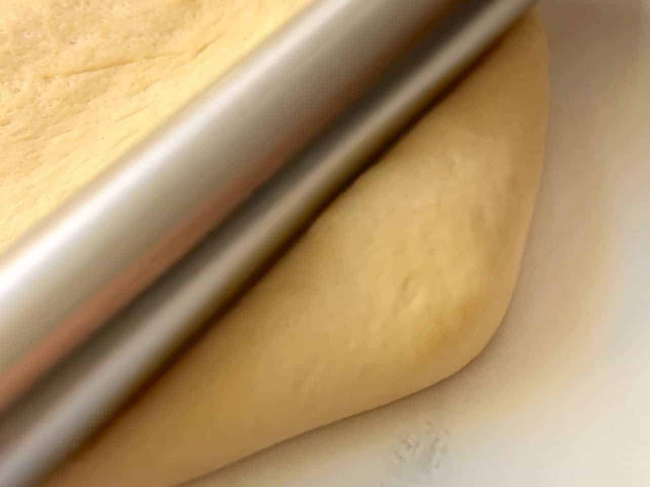 roll cinnamon roll dough corners evenly to achieve rectangle shape
